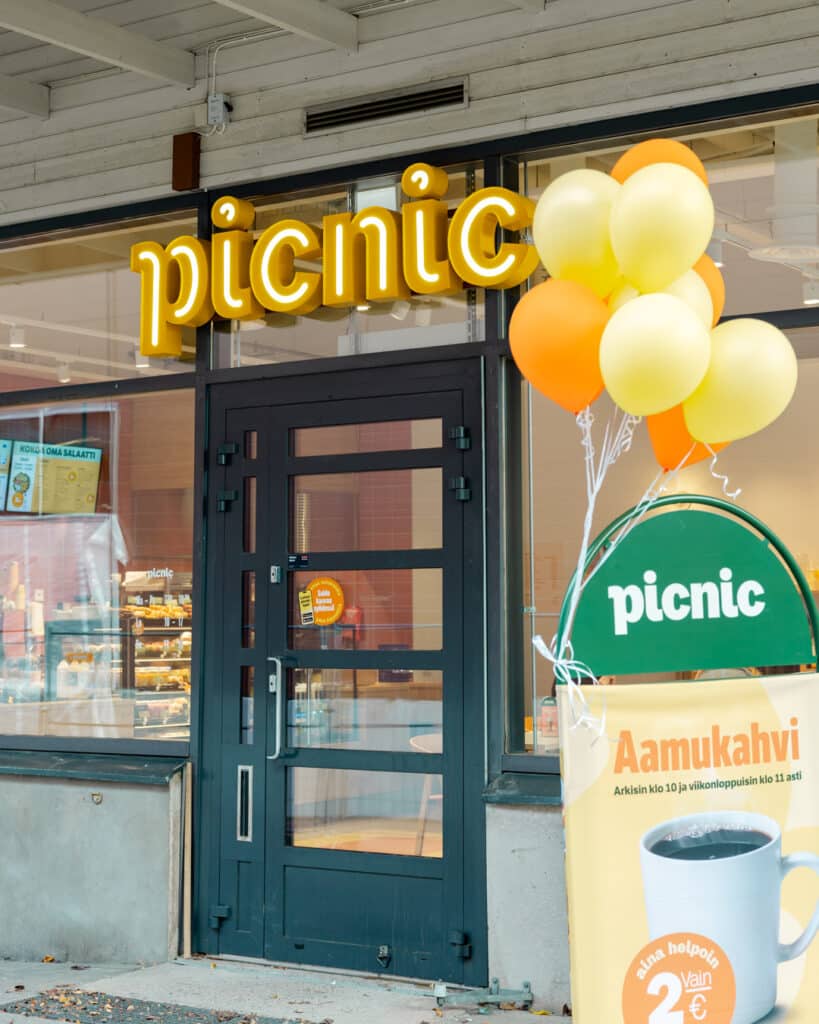 Tuusulan uuden Picnic-ravintolan sisäänkäynti, jonka edessä on kyltti ja siihen kiinnitettynä keltaisia ilmapalloja.